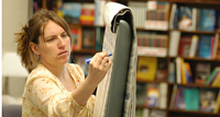 Picture of woman writing on marker board.