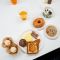 a collection of breakfast foods spread out on a white table